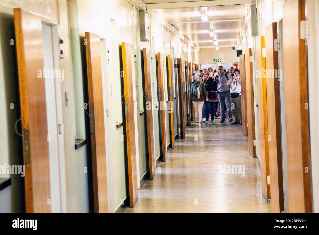 Les touristes font la queue pour visiter la cellule où Mandela a dormi pendant 18 ans. Il y a beaucoup de cellules mais les touristes veulent voir seulement une d'entre elles. Banque D'Images