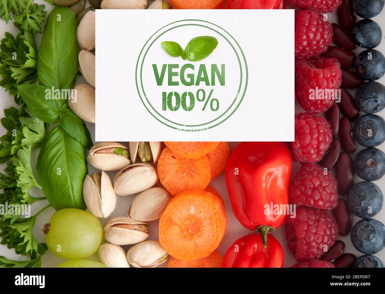Carte avec cachet végétalien et basilic sur les fruits et légumes assortis Banque D'Images