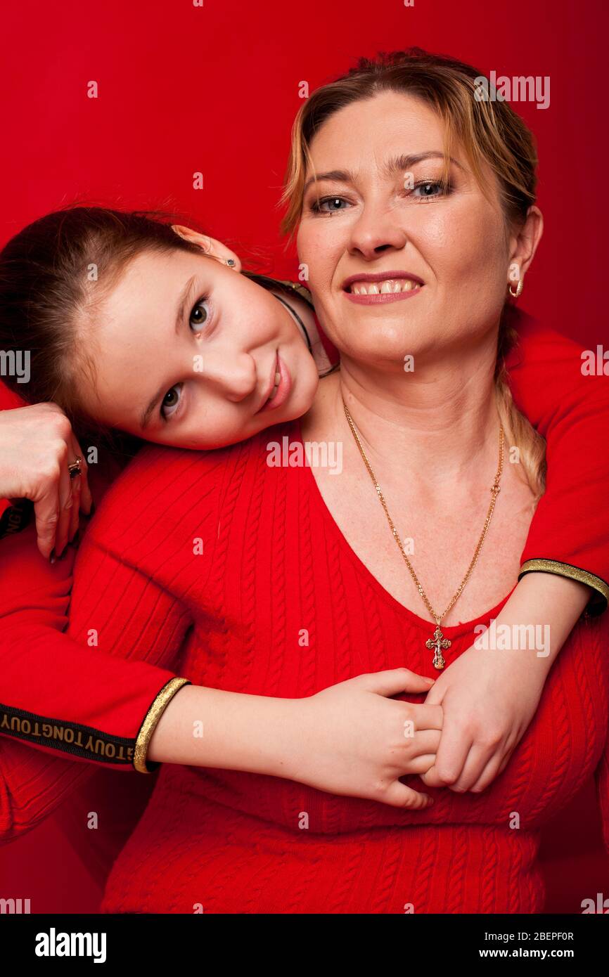 Maman et fille en robe rouge famille de câlins Banque D'Images