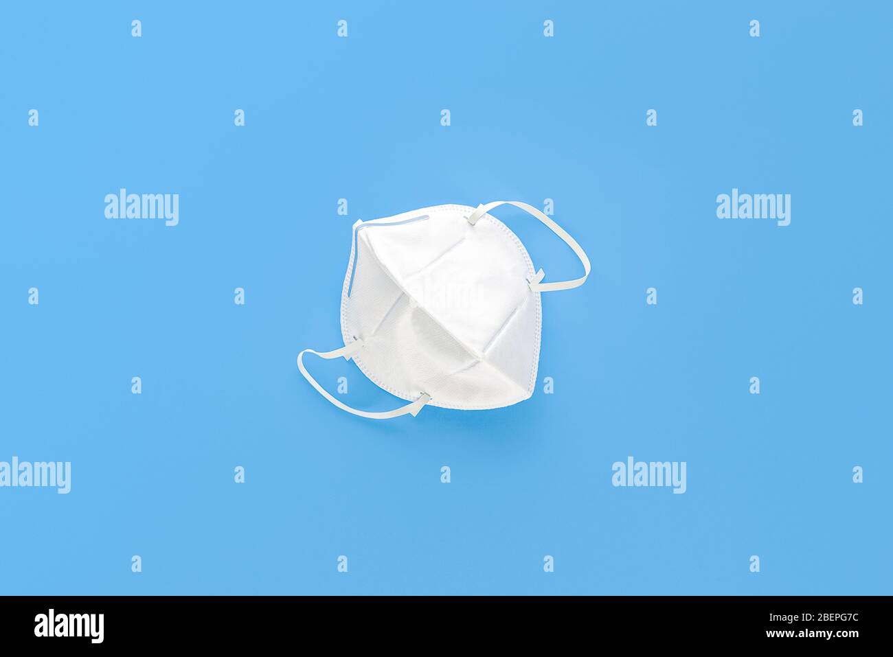Masque de protection contre les PM2,5 de poussière et les virus isolés sur fond bleu clair Banque D'Images