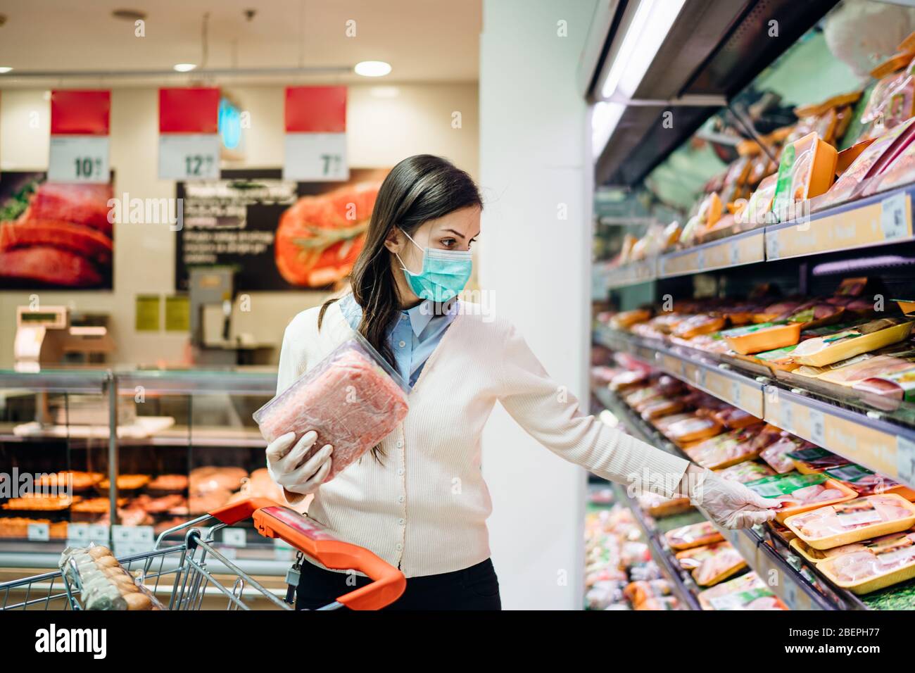 Acheteurs avec masque acheter en toute sécurité pour les produits alimentaires en raison de la pandémie de coronavirus dans une épicerie.COVID-19 achats de viande et de produits animaux.quarantaine p Banque D'Images