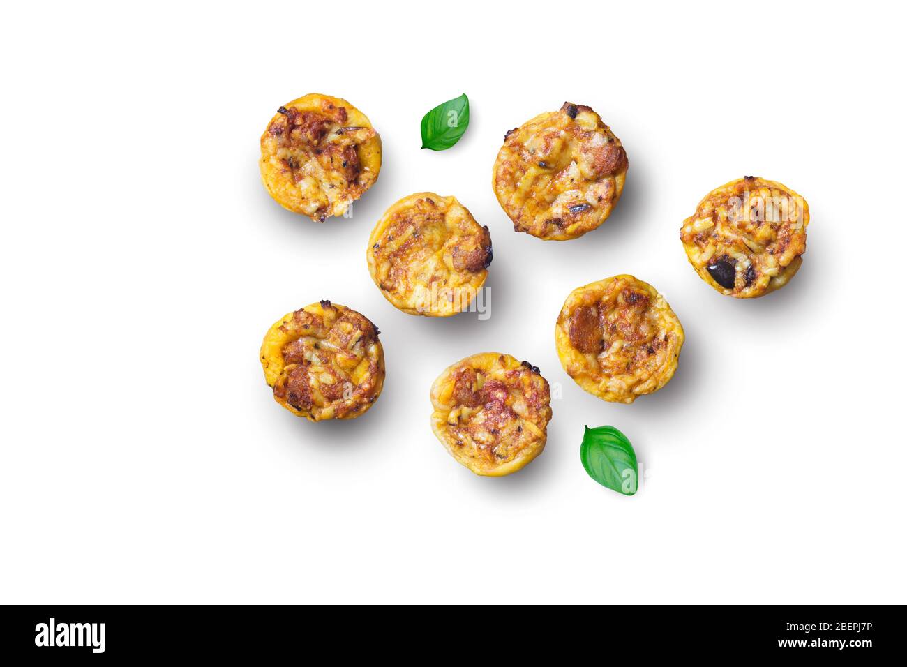 Mini tartes salées avec fromage, olives, herbes et morceaux de chorizo saucisse - petits tartelettes appétissantes isolées sur fond blanc Banque D'Images