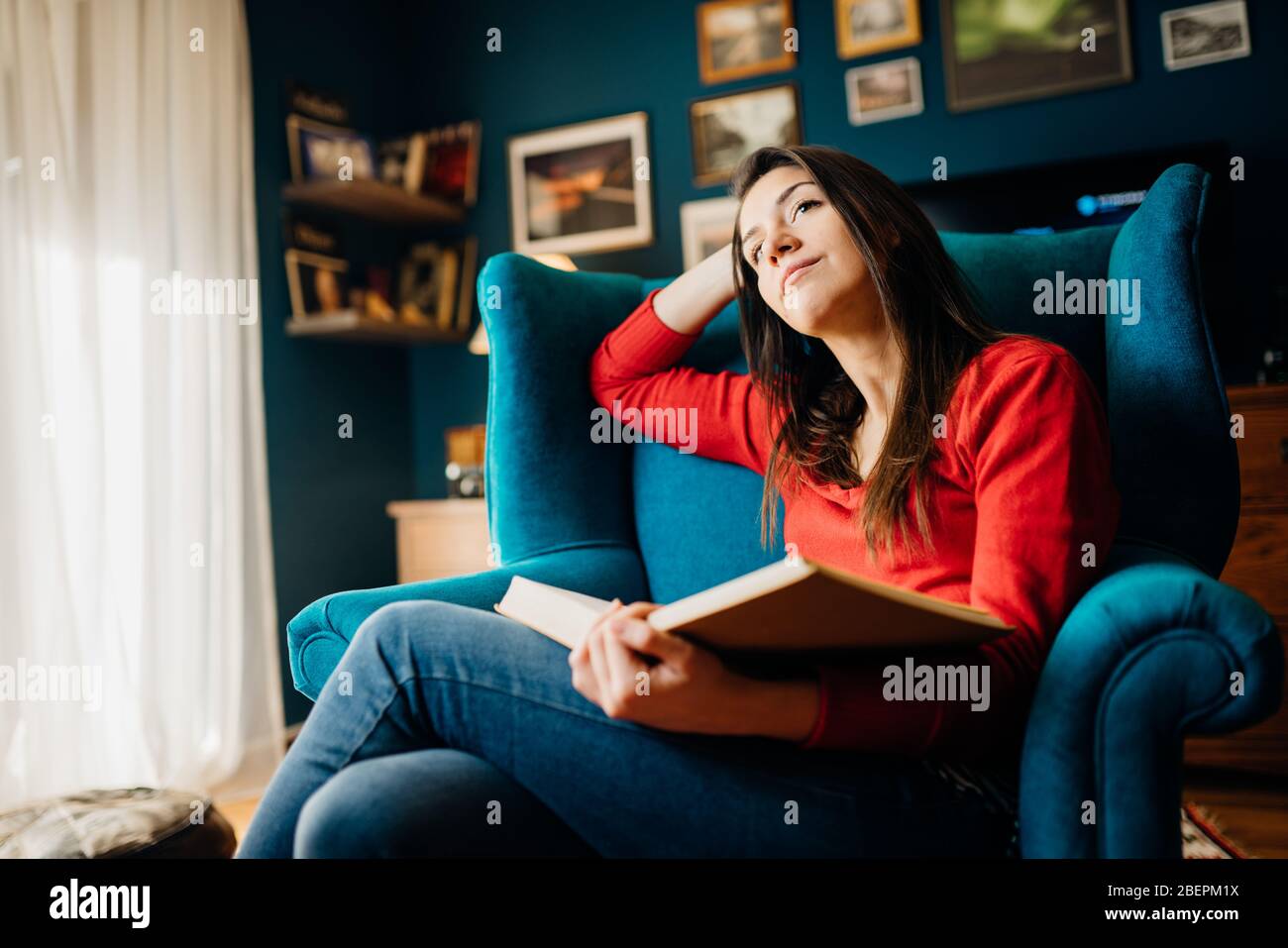 Femme pensant/imaginant au sujet d'un roman d'amour livre d'histoire nouvelle elle est la lecture, maison seule en quarantaine.Romantique femme imagination.Santé mentale auto c Banque D'Images