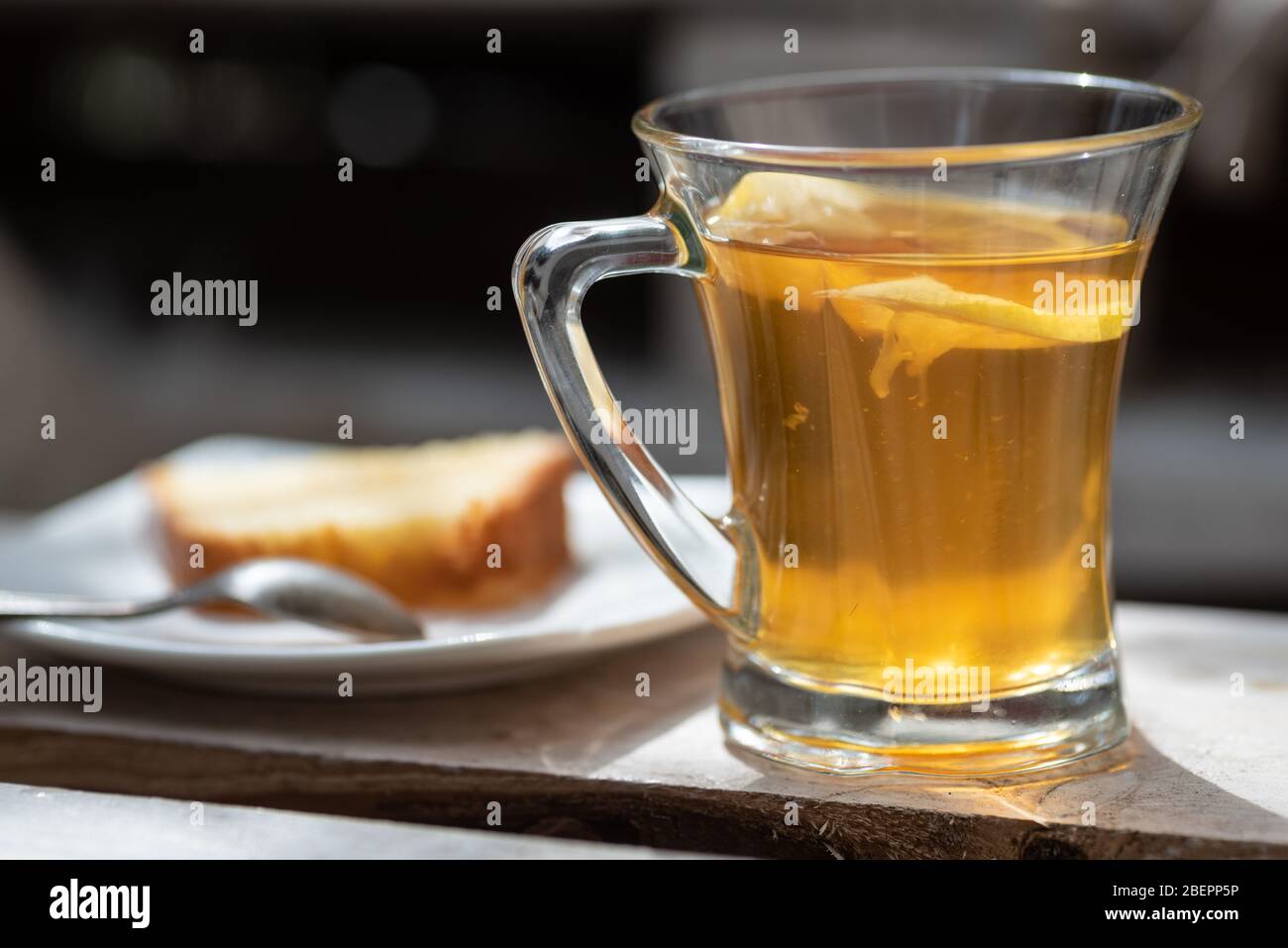 Un verre de thé noir ou vert frais préparé avec du citron préparé pour le petit déjeuner servi à l'extérieur le jour ensoleillé Banque D'Images