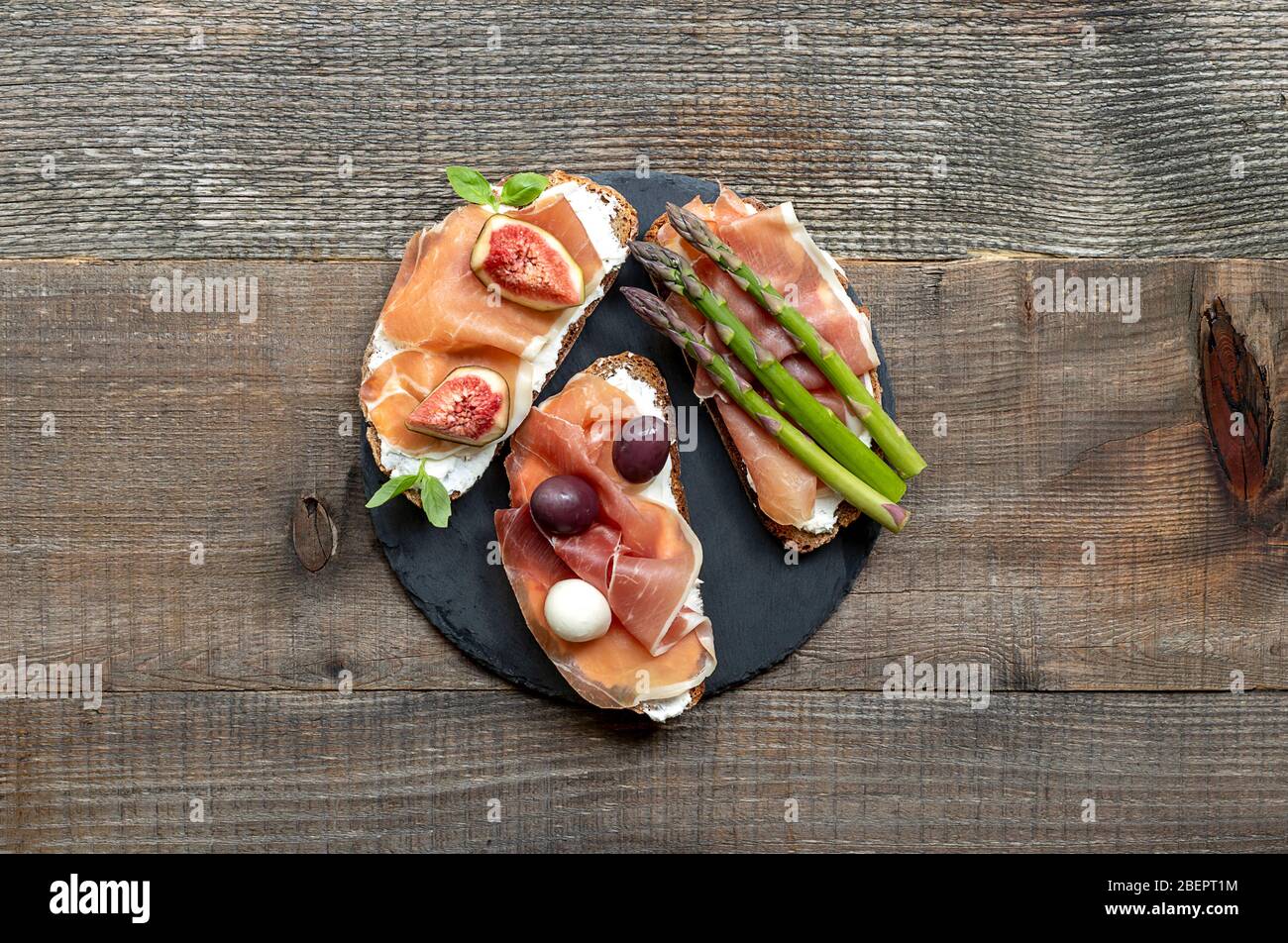 Collations à la bruschetta. Variété de délicieux sandwiches sur fond de bois rustique ancien, vue de dessus. Banque D'Images