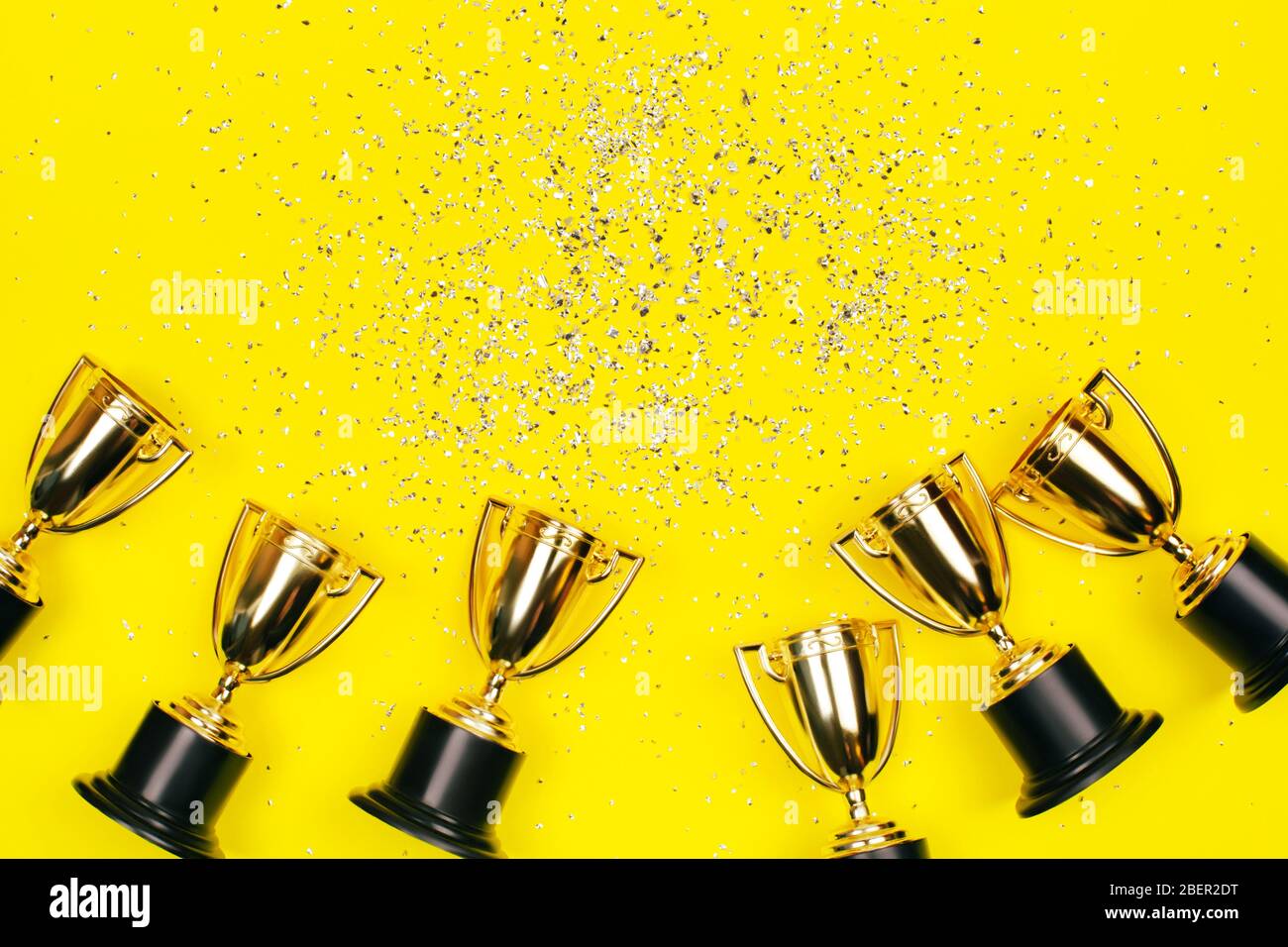 Coupes Golden Winner avec des taches d'argent sur un fond jaune avec espace de copie. Concept festif. Style plat. Banque D'Images