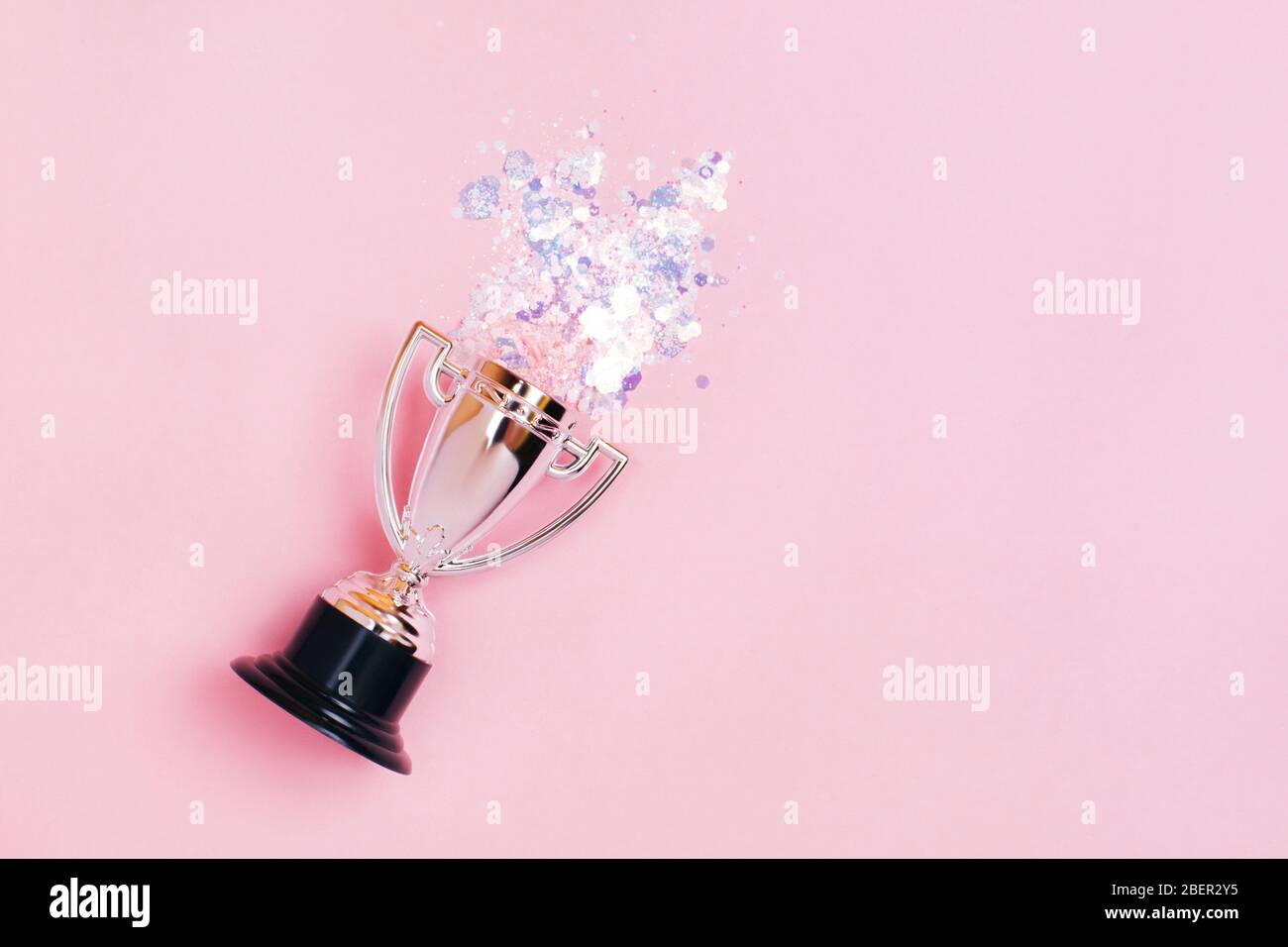 Une tasse gagnante en argent aux couleurs vives sur fond pastel. Style lat Lay. Banque D'Images