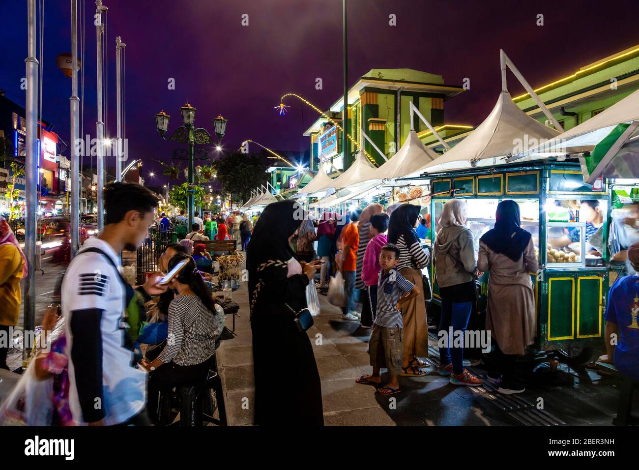 Indonésie les gens qui achètent de la nourriture de la rue stalles de nourriture dans la rue Malioboro, Yogyakarta, Indonésie. Banque D'Images