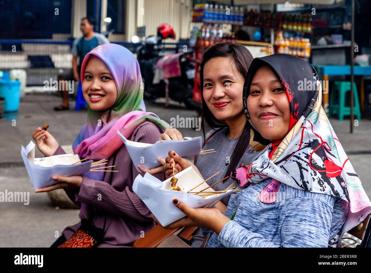 Jeunes femmes indonésiennes manger la nourriture de rue, rue Malioboro, Yogyakarta, Indonésie. Banque D'Images