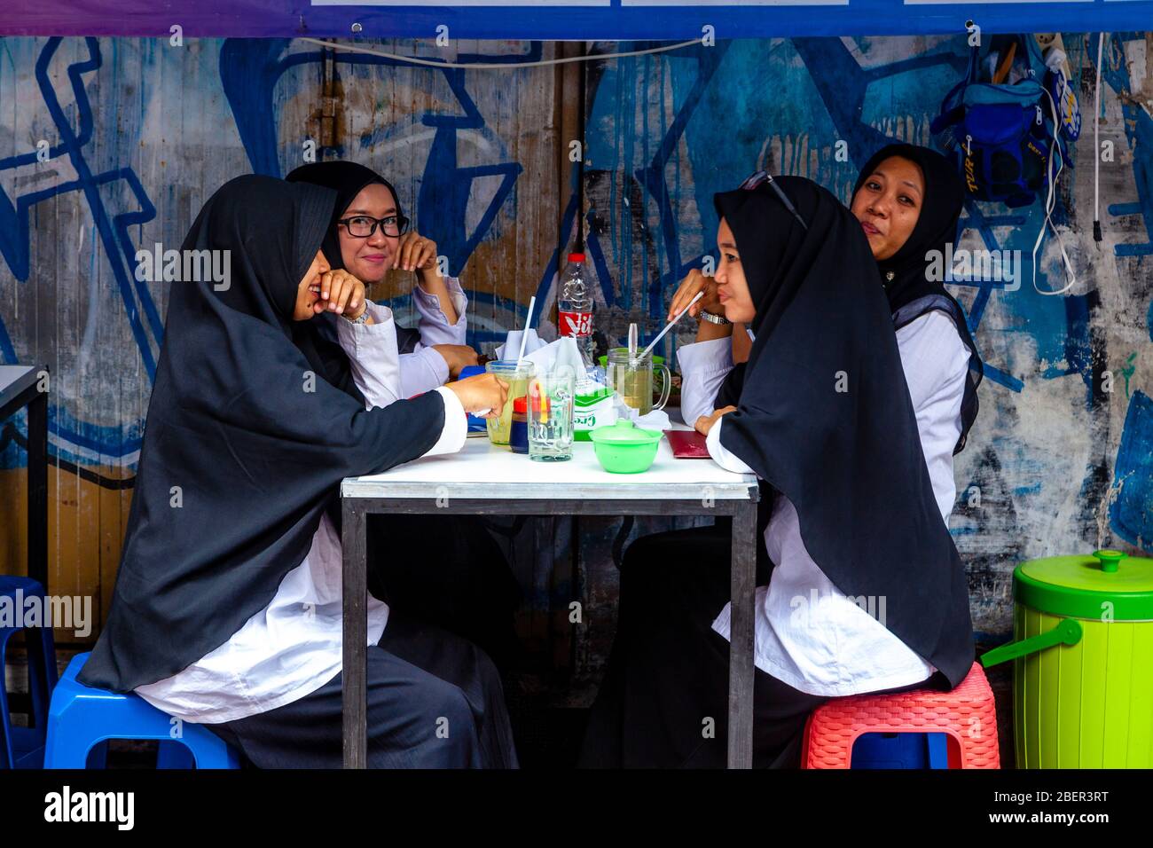 Jeunes femmes indonésiennes en buvant des boissons gazeuses au café de la rue Malioboro, Yogyakarta, Indonésie. Banque D'Images