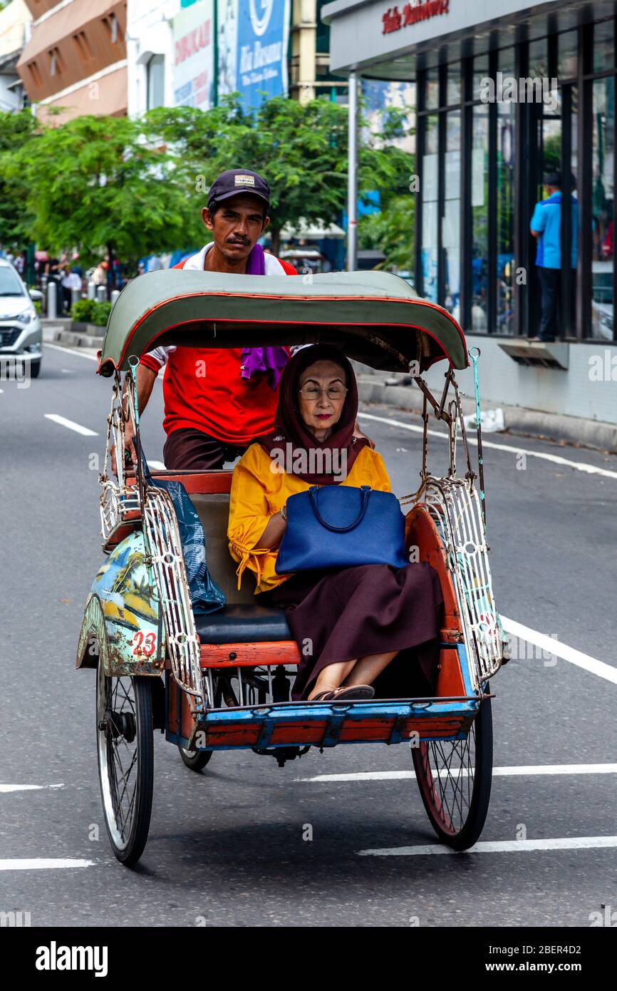 Une femme locale voyageant par becak (vélo Rickshaw), Yogyakarta, Indonésie. Banque D'Images