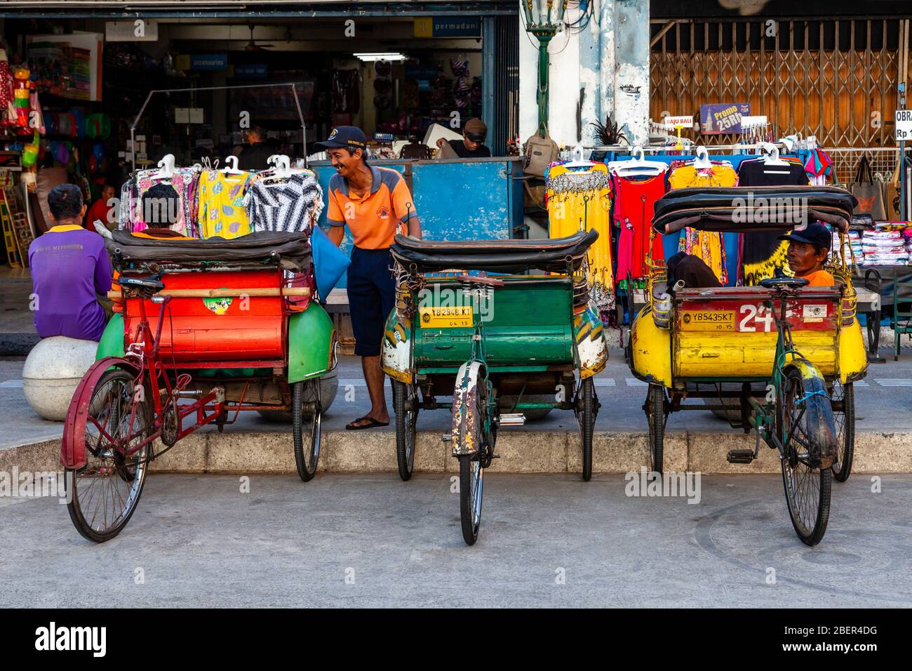 Les pics colorés (pousse à vélo) et leurs pilotes, rue Malioboro, Yogyakarta, Indonésie. Banque D'Images