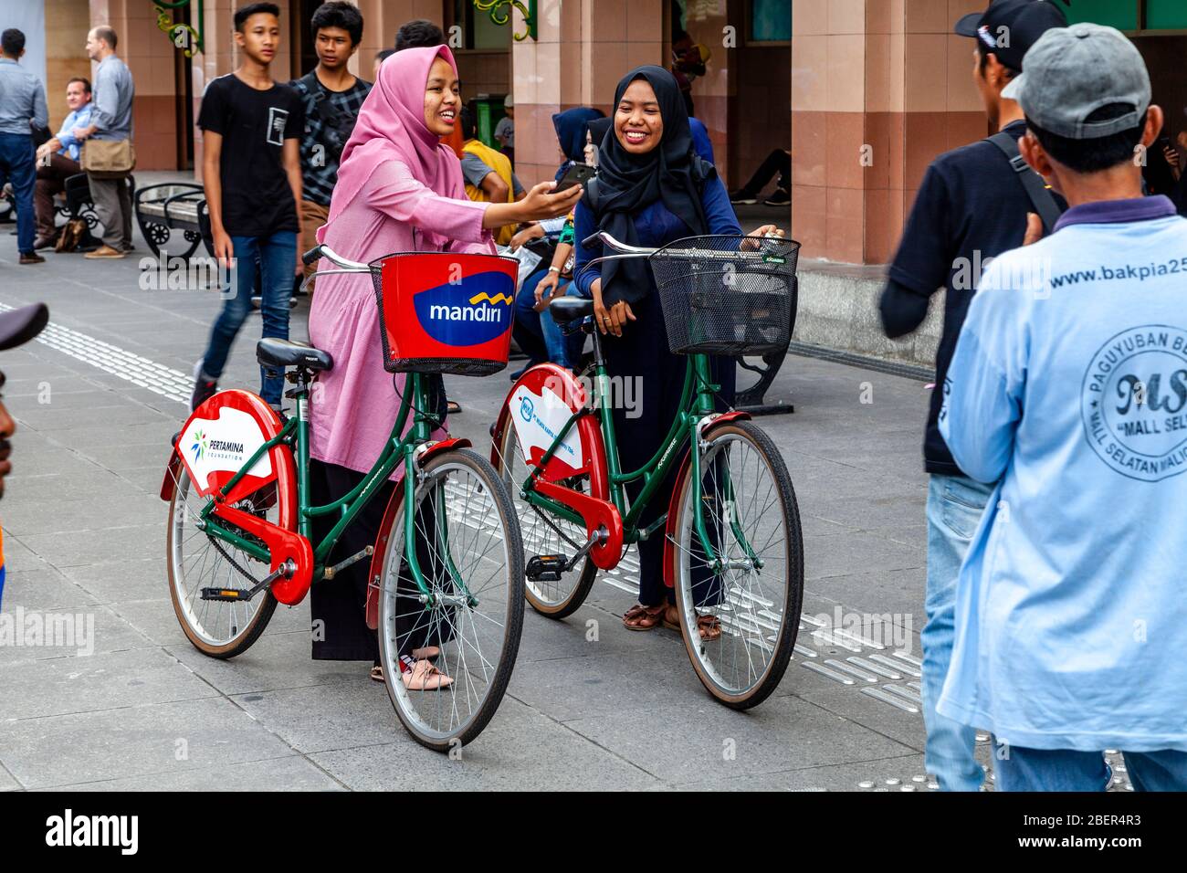 Deux femmes indonésiennes avec leurs vélos dans la rue Malioboro, Yogyakarta, Java, Indonésie. Banque D'Images