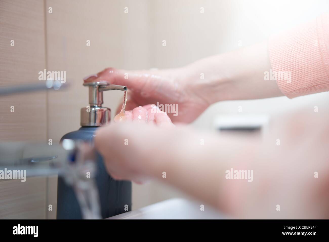 Lavage des mains avec du savon sous l'eau dans la salle de bains Banque D'Images