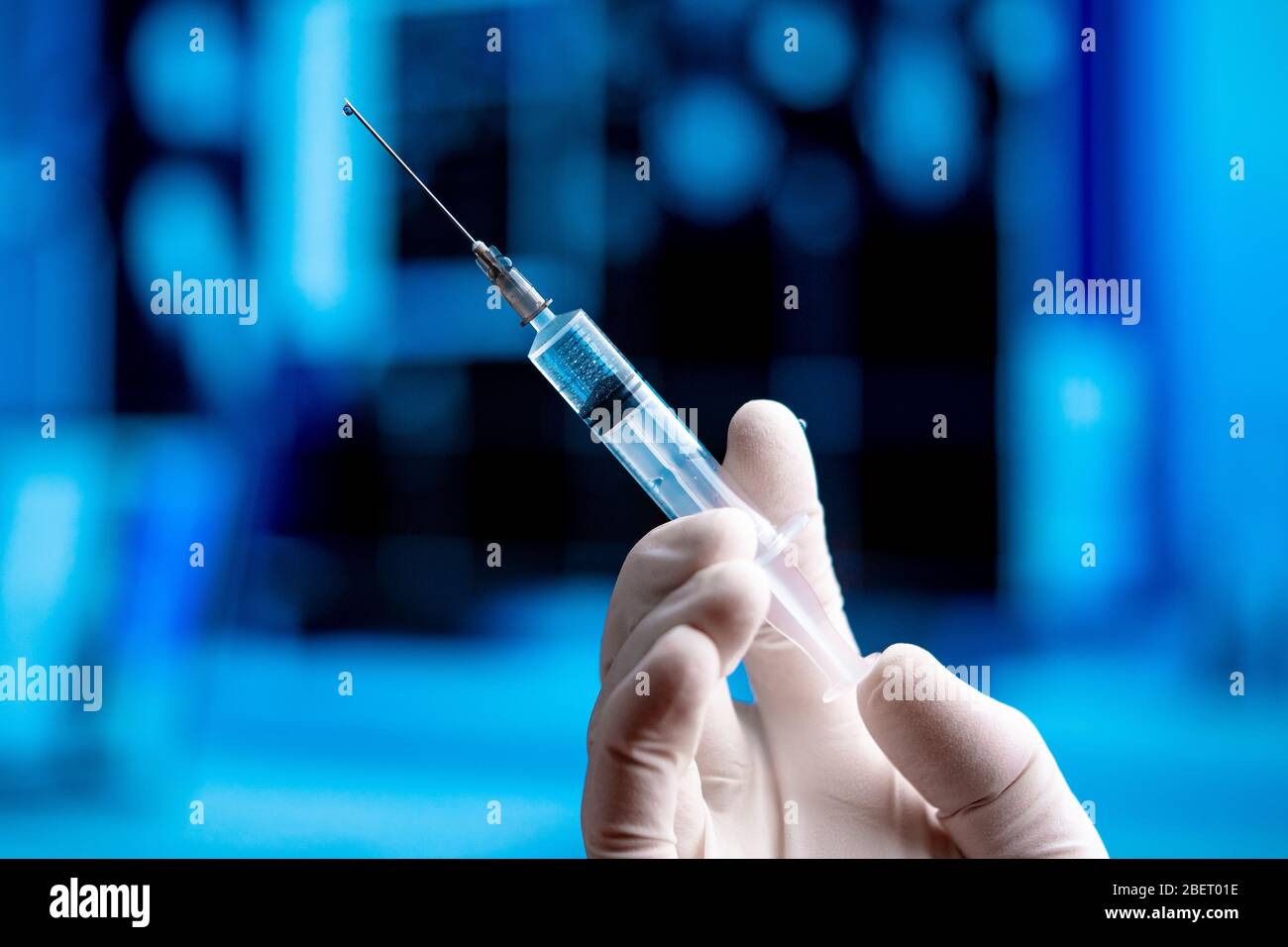 Main de médecin dans les gants blancs contenant la seringue avec un vaccin avant l'immunisation et la vaccination. Médecine du SRAS Coronavirus, 2019-nCoV dans Blue Laboura Banque D'Images