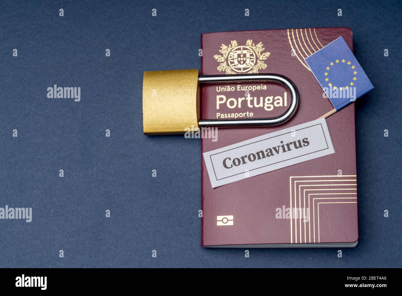 Passeport portugais européen de voyage avec cadenas sur fond bleu. Banque D'Images