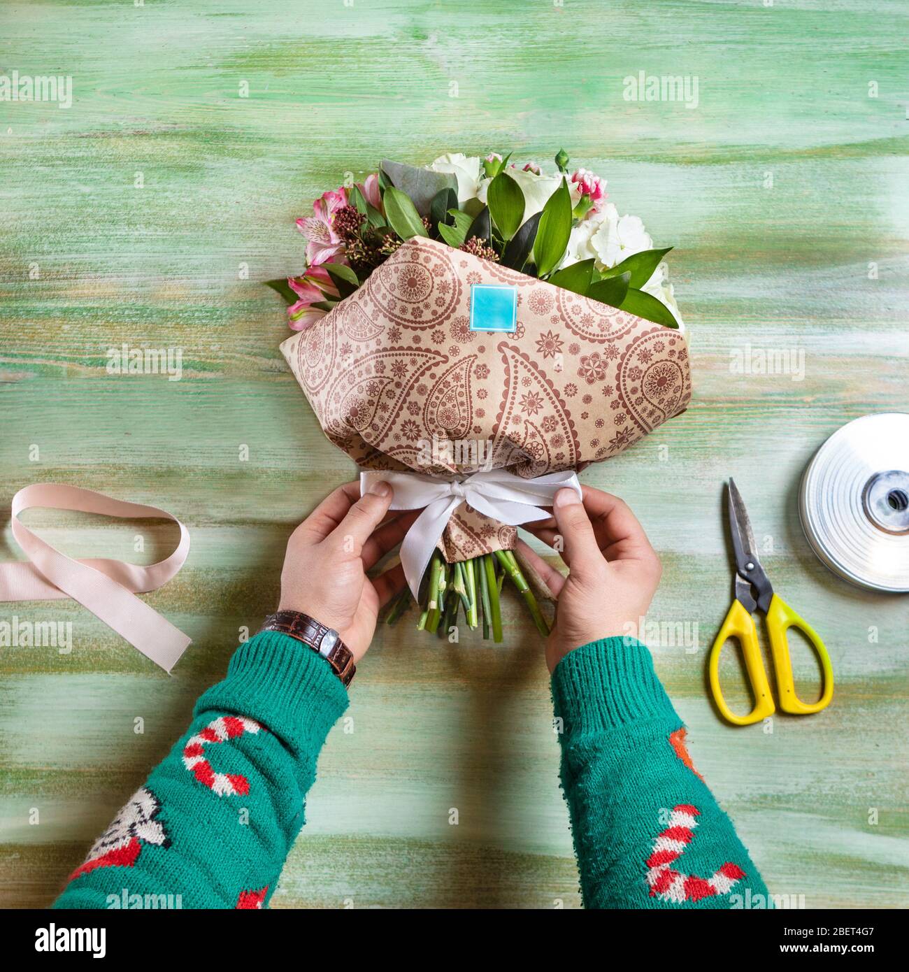 Fleuriste homme faisant bouquet de fleurs sur la table Banque D'Images