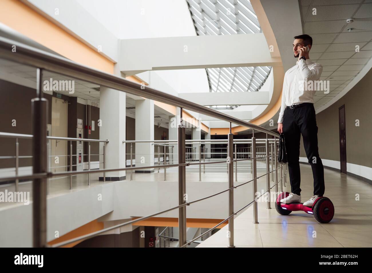 Un jeune homme d'affaires est en gyroplanche. Il parle sur le smartphone Banque D'Images