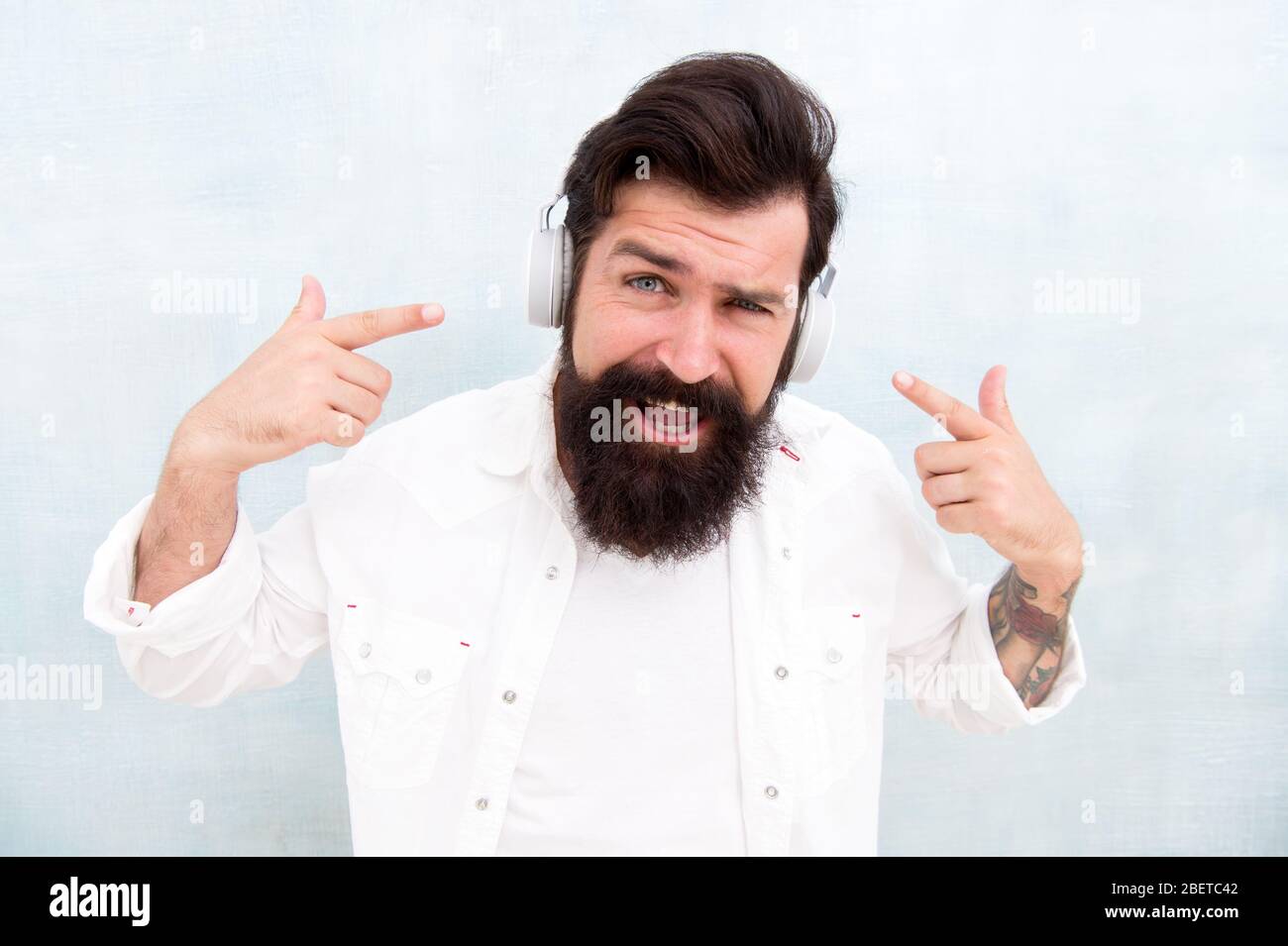 Technologie d'annulation active du bruit. Hipster écoute des écouteurs stéréo. Casque sans fil moderne. Pistes de musique de danse électroniques. Musique instrumentale. Casque homme barbu. Profitez de chaque note. Banque D'Images