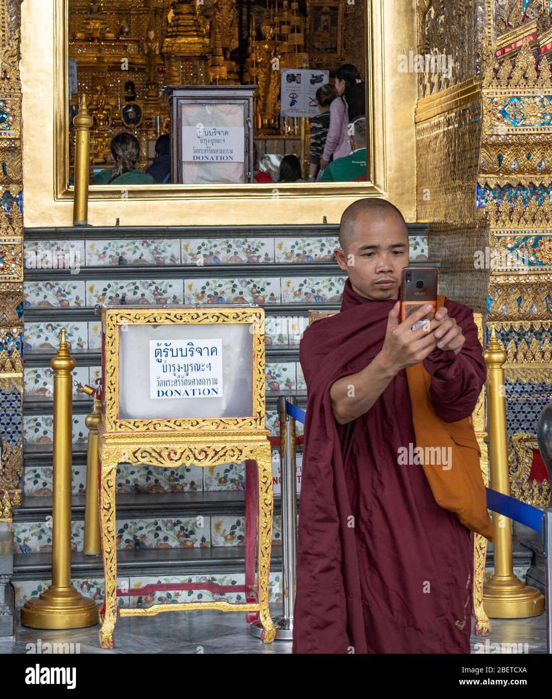 Bangkok, Thaïlande - 29 février 2020: Un moine bouddhiste prenant un selfie devant le temple du bouddha émeraude, dans la cour du grand palais, Bang Banque D'Images