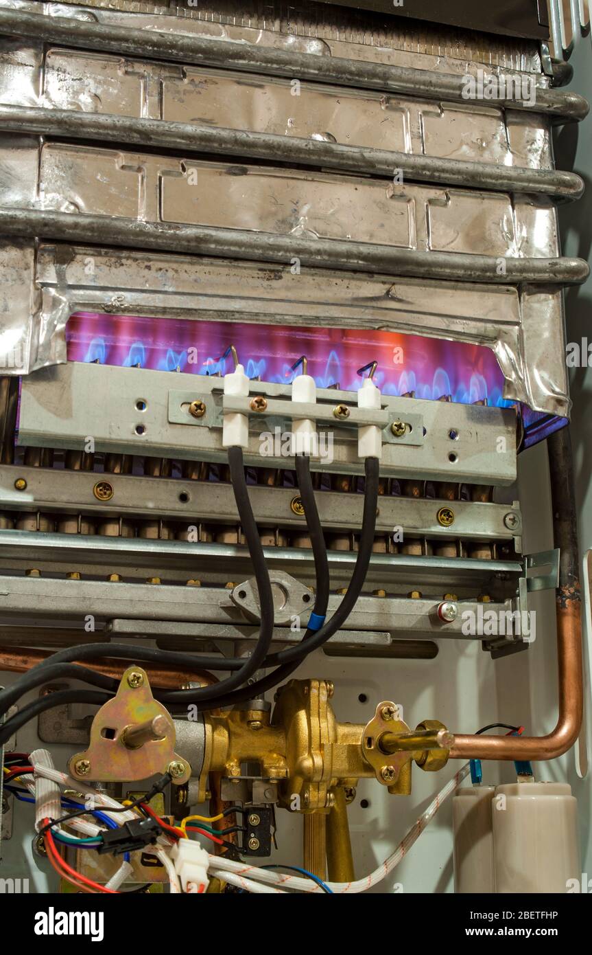 Le gaz brûle dans le chauffe-eau moderne sans boîtier de protection Banque D'Images