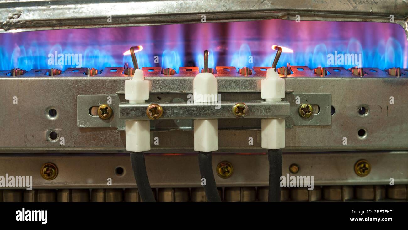 Le gaz brûle dans le chauffe-eau moderne sans boîtier de protection Banque D'Images
