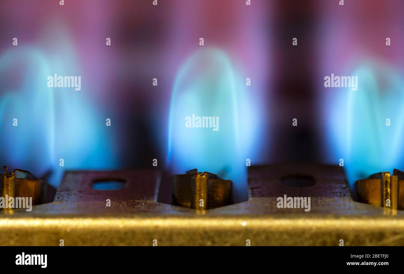 Le gaz brûle dans le chauffe-eau moderne. Gros plan. Mise au point sélective. Banque D'Images