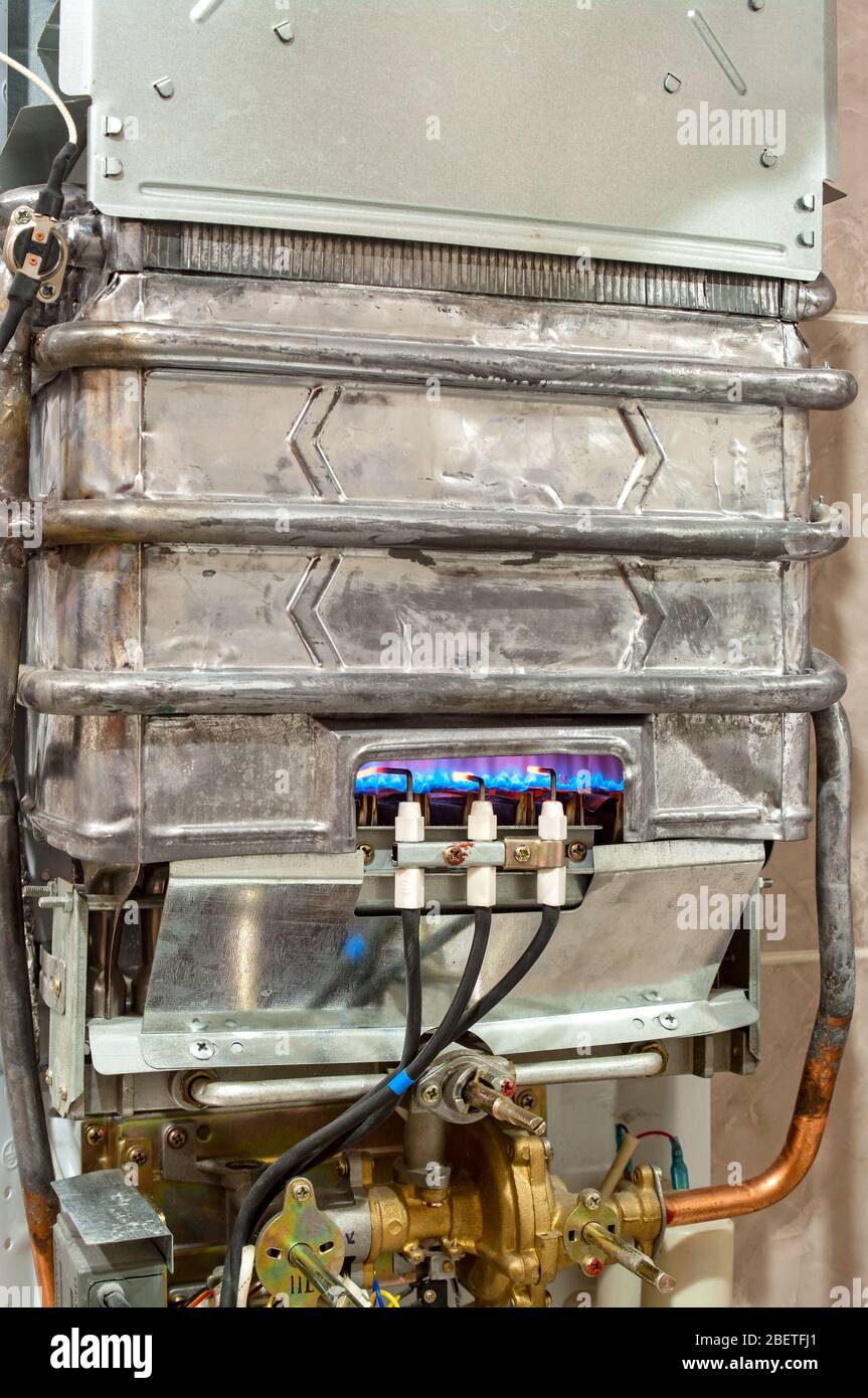 Le gaz brûle dans le chauffe-eau moderne sans boîtier de protection Banque D'Images