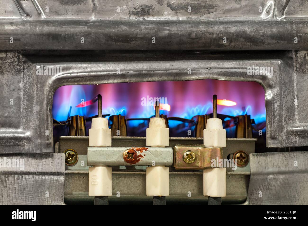 Le gaz brûle dans le chauffe-eau moderne sans boîtier de protection Banque D'Images