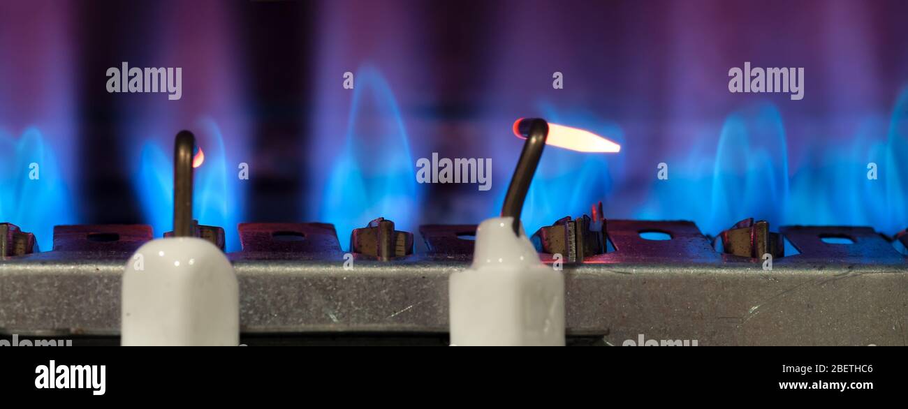 Le gaz brûle dans le chauffe-eau moderne. Gros plan. Mise au point sélective. Banque D'Images