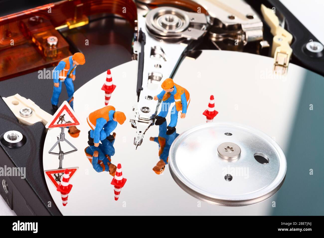 Image conceptuelle des personnes à figure miniature recherchant des problèmes sur un disque dur d'ordinateur Banque D'Images