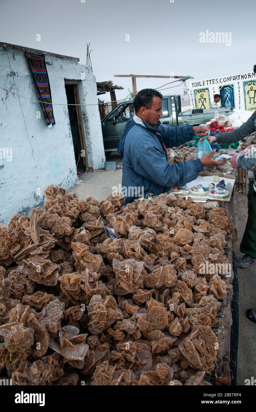 Un homme qui vend des roses du désert dans la rue en Tunisie Banque D'Images