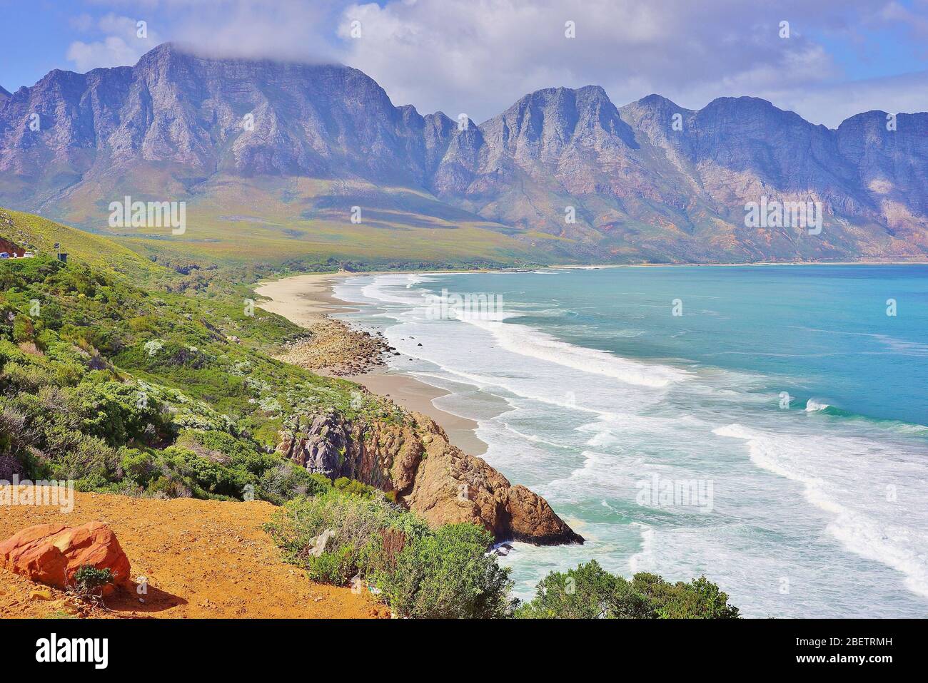 Magnifique littoral sud-africain le long de Garden route avec une baie pittoresque avec une longue plage solitaire et de hauts Mountians en arrière-plan. Banque D'Images