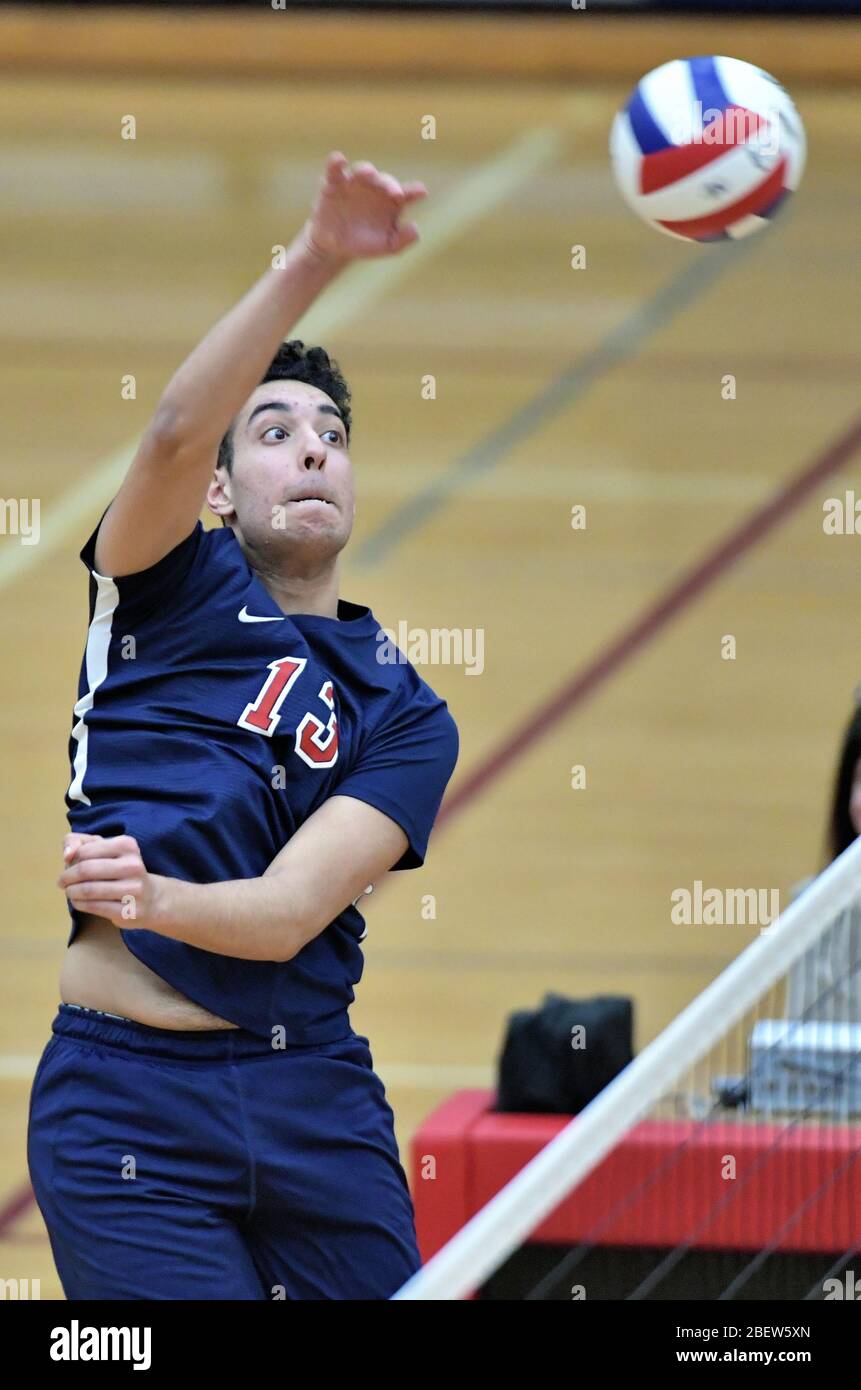 Joueur qui délivre un tir de tuer pendant un match de volley-ball universitaire. ÉTATS-UNIS. Banque D'Images