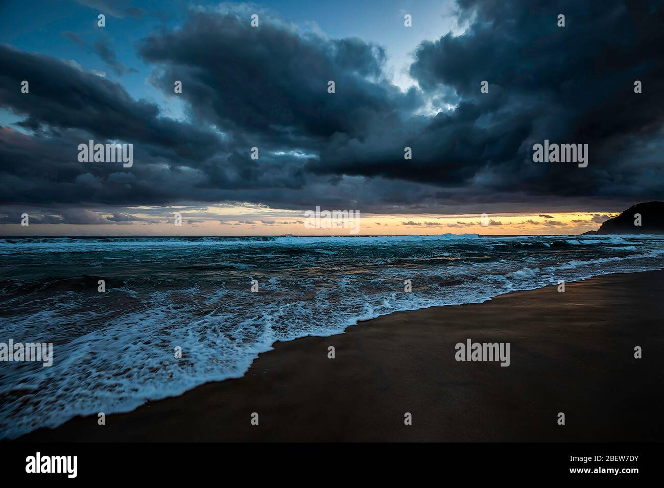 Coucher de soleil sur la plage avec de lourds nuages Banque D'Images