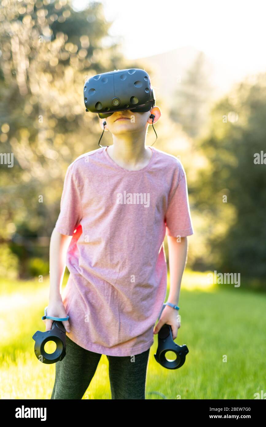 Garçon debout avec la technologie VR pendant la journée ensoleillée Banque D'Images