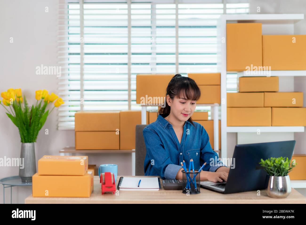Propriétaire asiatique femme d'affaires travailler à la maison pour les achats en ligne, discuter avec le client son ordinateur portable avec l'équipement de bureau, style de vie d'entrepreneur Banque D'Images