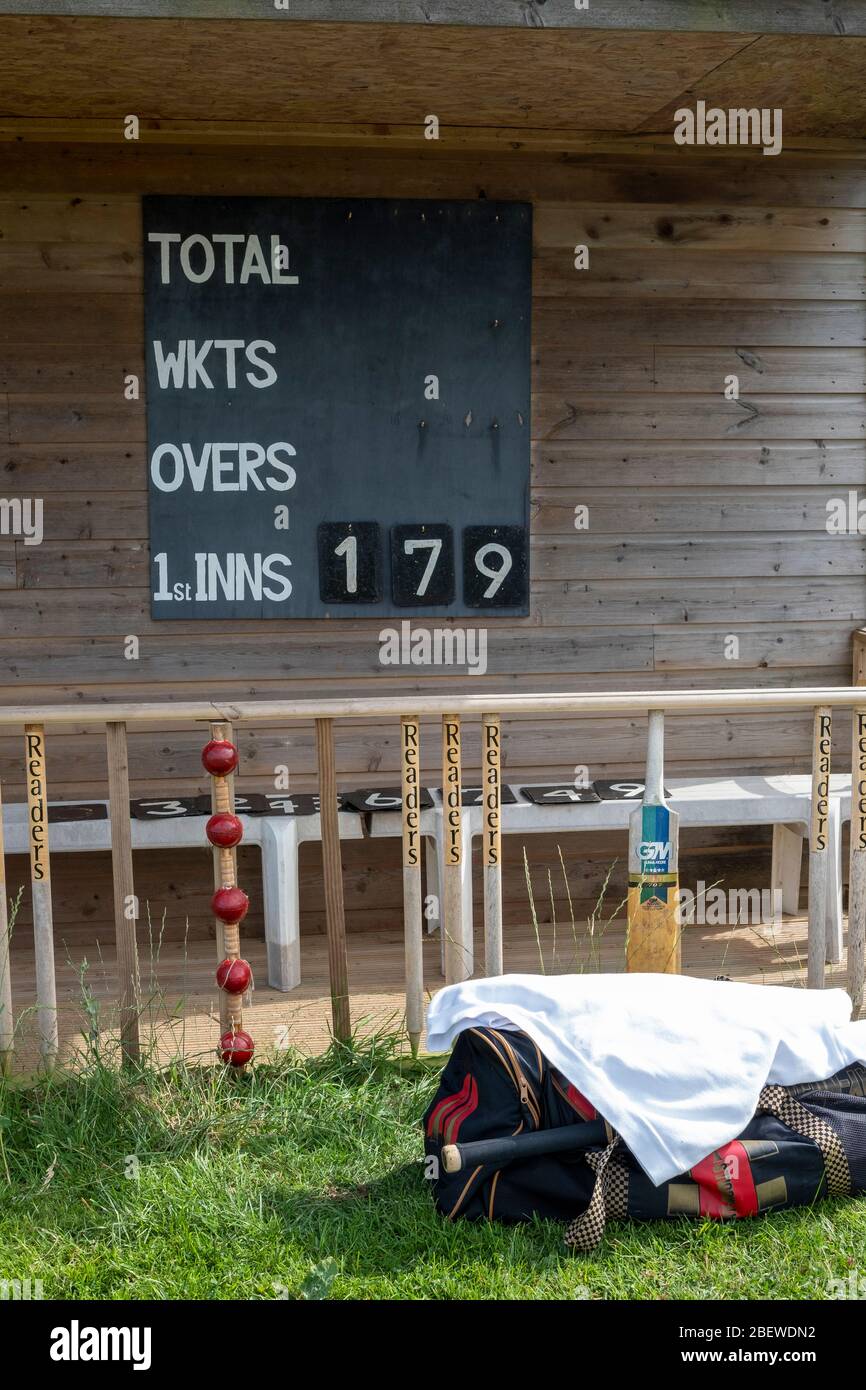 Match de cricket du village à Stoke Fleming, Devon, le pavillon avec tableau de bord et clôture en vieux souches, chauves-souris et balles Banque D'Images
