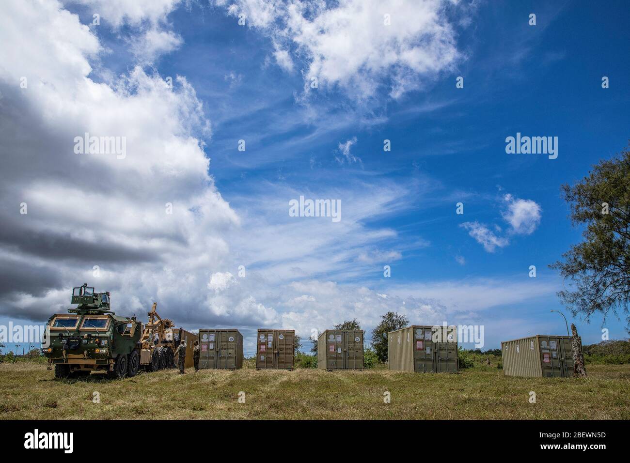 DEDEDEDO, Guam (14 avril 2020) UN corps maritime américain MKR18 Cargo Logistic Vehicle System Replacement (LVSR) décharge un conteneur de l'Organisation internationale de normalisation avec des matériaux pour la construction d'un centre médical expéditionnaire (EMF), le 14 avril 2020. Le FEM fournira des capacités médicales étendues à l’appui de la réponse COVID-19 du Département de la défense et permettra aux forces d’être postcontraintes de soutenir Guam et la région si une mission de soutien à la défense des autorités civiles est demandée. (ÉTATS-UNIS Photo du corps marin par Sgt. Hailey D. Clay) Banque D'Images