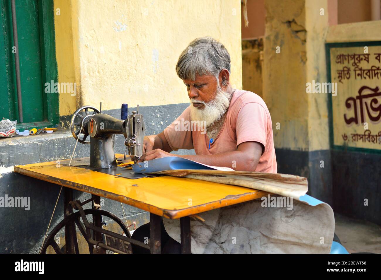 Kolkata, Inde - 16 juillet 2017 : un tailleur à coudre des vêtements avec sa machine à coudre. Banque D'Images