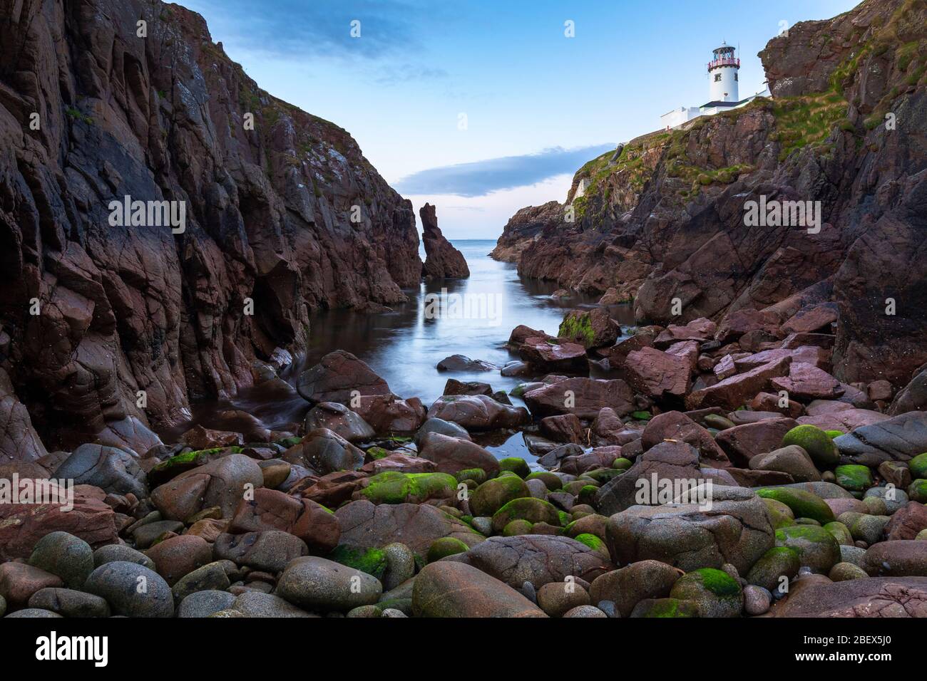 Vue sur un coucher de soleil depuis la crique sous le phare de Fanad Head (Fánaid), County Donegal, région d'Ulster, Irlande, Europe. Banque D'Images