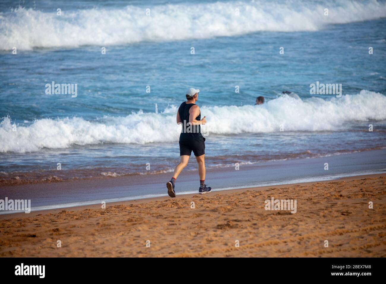 Homme australien qui fait du jogging sur la plage avalon de Sydney pendant l'éclosion de coronavirus pour rester en forme, Sydney, Australie Banque D'Images