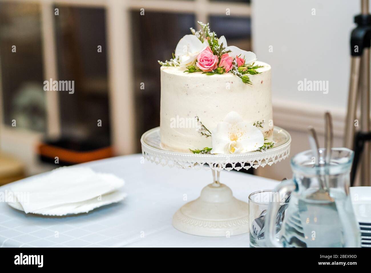 Gâteau de mariage à la crème blanche avec décoration de fleurs dessus. Banque D'Images