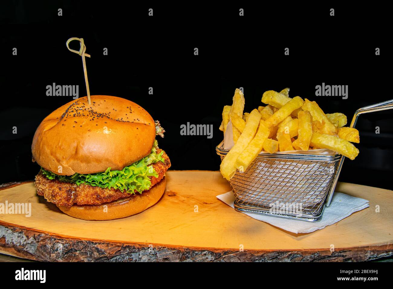 Un hamburger de poulet pané croustillant servi avec une portion de frites Banque D'Images