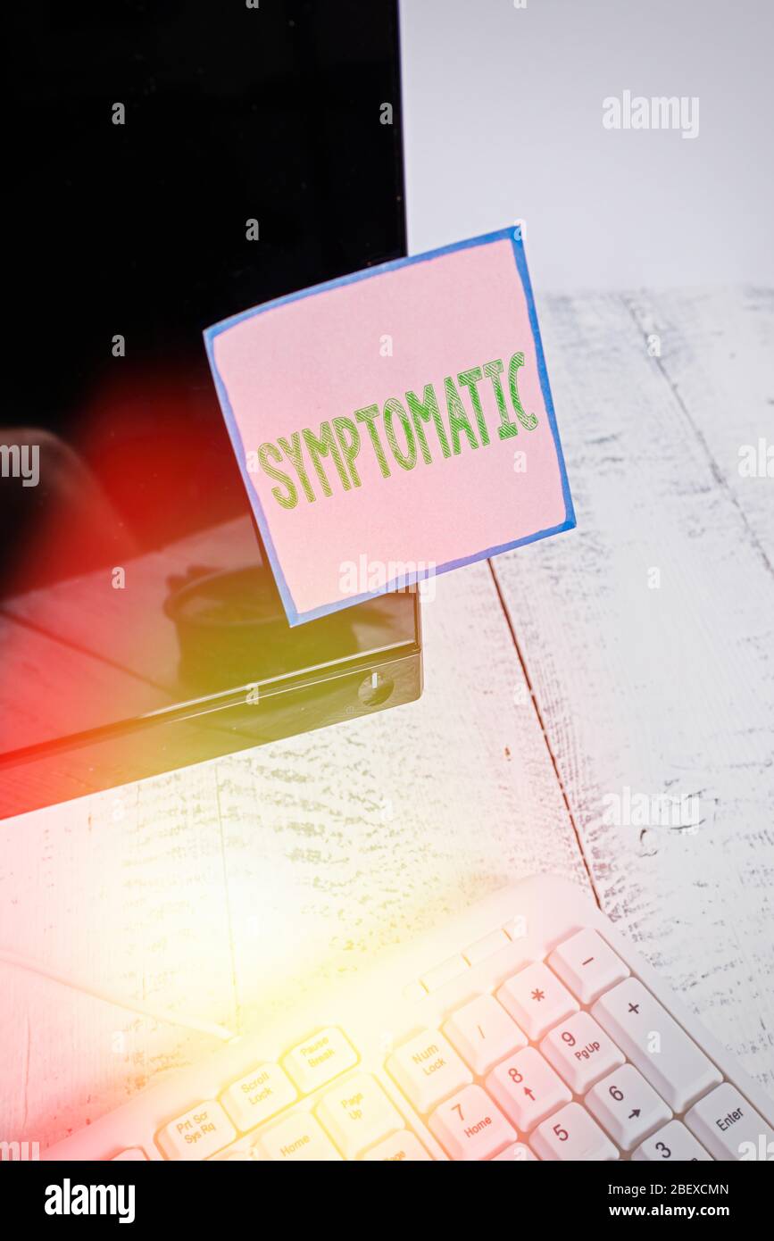 Note d'écriture montrant symptomatique. Concept commercial pour servir de symptôme ou signe, en particulier de quelque chose indésirable Note papier collé à la comput noire Banque D'Images