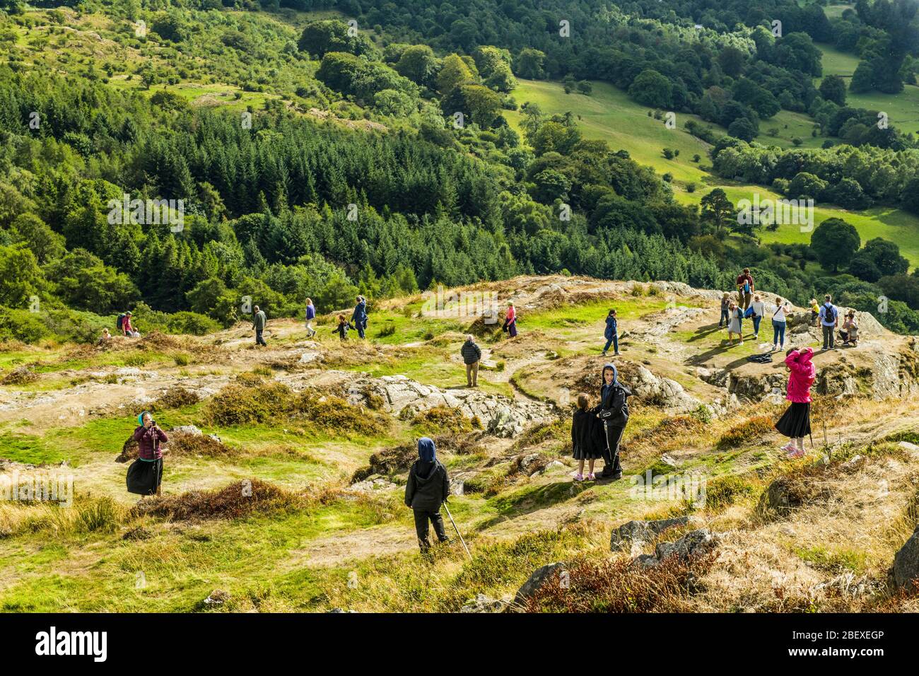 Les visiteurs qui marchent sur les pistes de Gummers How, qui surplombe Windermere dans le parc national du Lake District, en été. Banque D'Images