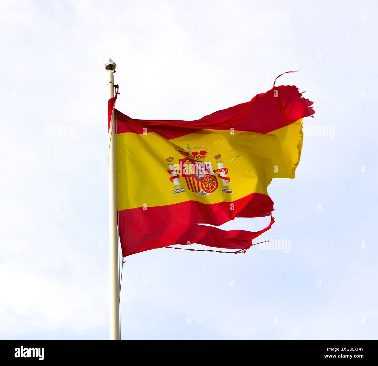 Drapeau espagnol déchiré soufflant dans le vent Banque D'Images