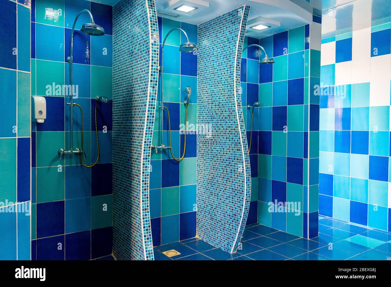 Salle de douche publique avec plusieurs douches. Grande salle de douche  publique claire et vide, avec murs et sol bleus Photo Stock - Alamy