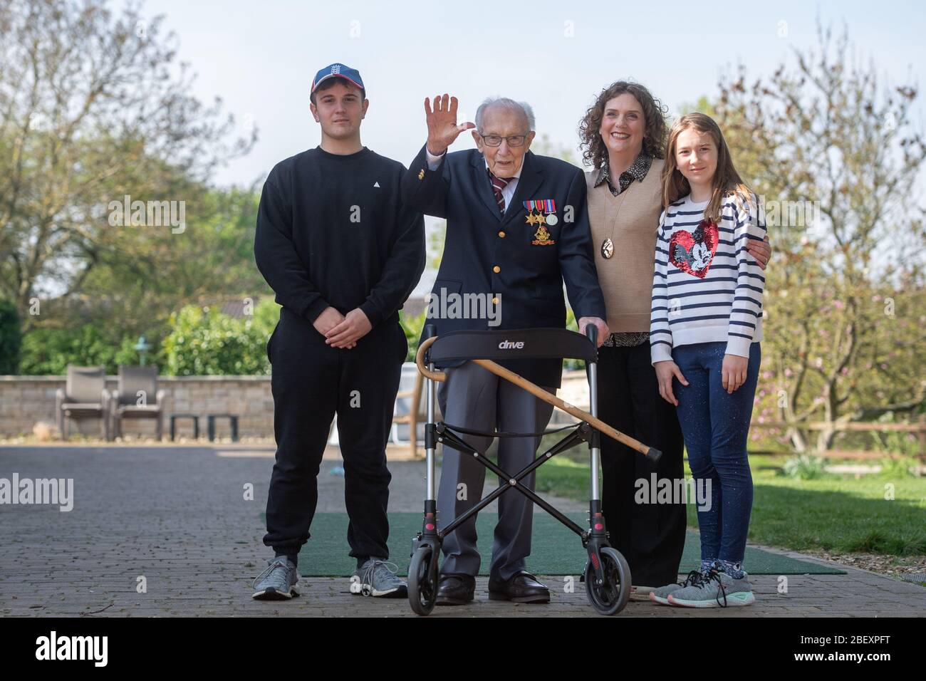 Le capitaine Tom Moore, vétéran de la guerre âgé de 99 ans, avec (de gauche à droite) le petit-fils Benji, sa fille Hannah Ingram-Moore et sa petite-fille Géorgie, dans sa maison de Marston Morelaine, dans le Bedfordshire, a atteint son objectif de 100 tours dans son jardin, soit une augmentation de plus de 12 millions de livres pour le NHS. Banque D'Images