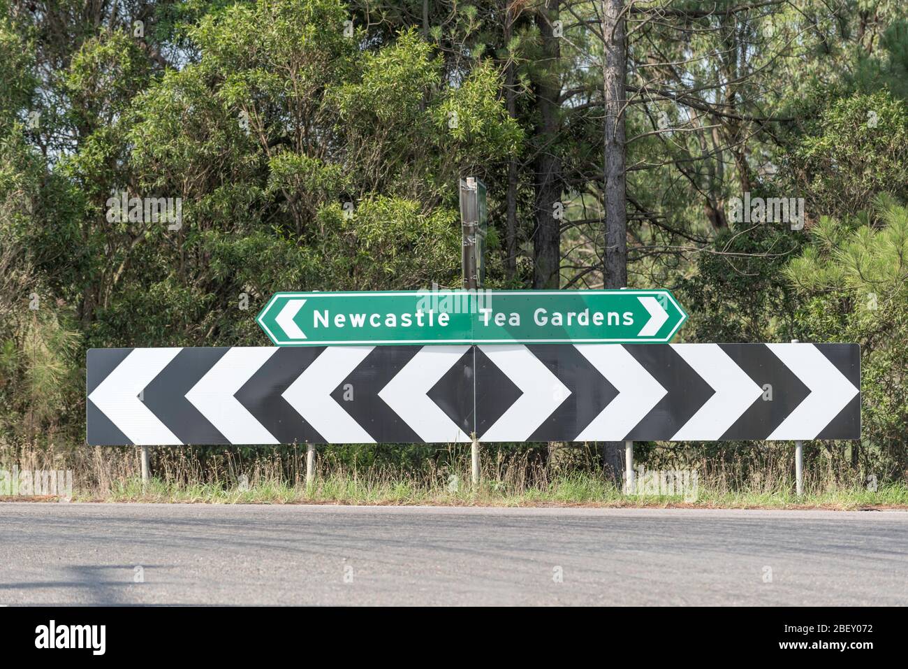 Un grand panneau de signalisation couleur zébrée peint en forme de zébra indiquant une jonction T sous un autre panneau pointant vers Newcastle dans une direction et Tea Gardens dans l'autre Banque D'Images